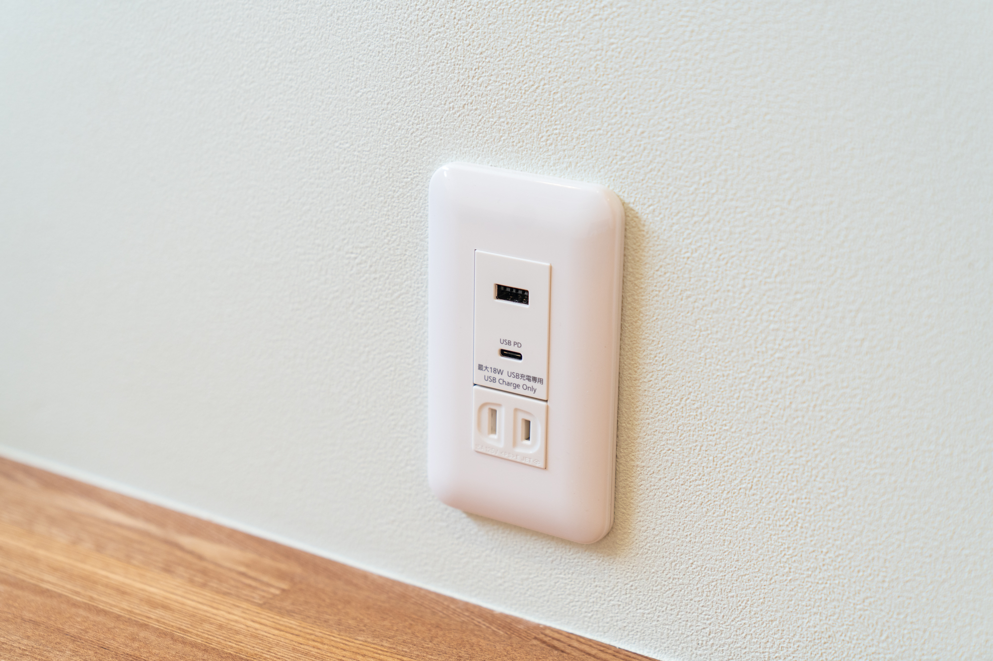壁付けの白い電源タップ。USB-A、USB PD対応のUSB-C。最大18Wの表記あり